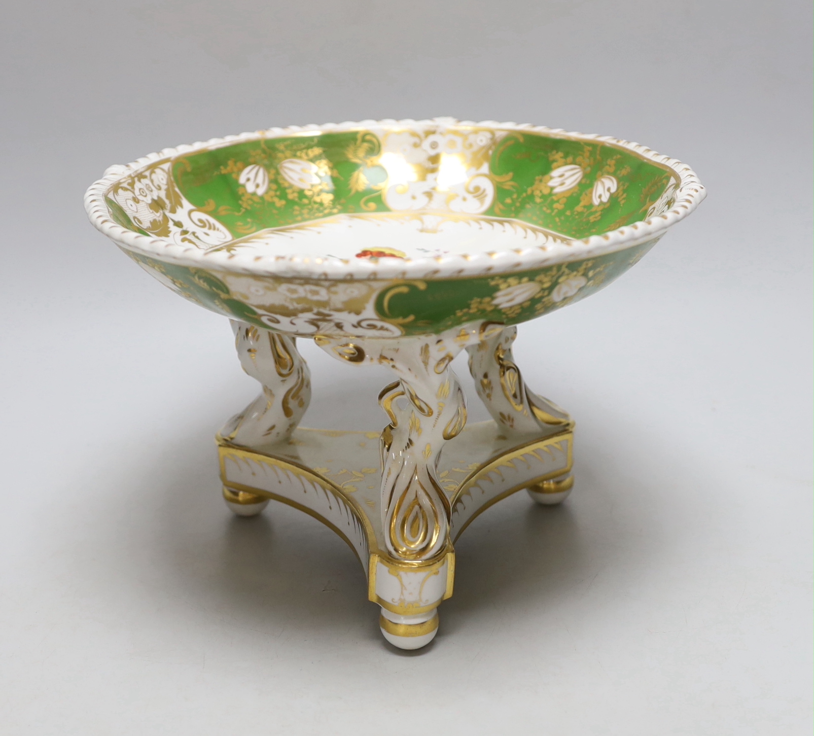 A Derby three footed comport, the centre painted with flowers, the border with green ground having four white gilded panels and four green gilded panels, c.1825, 17cm high